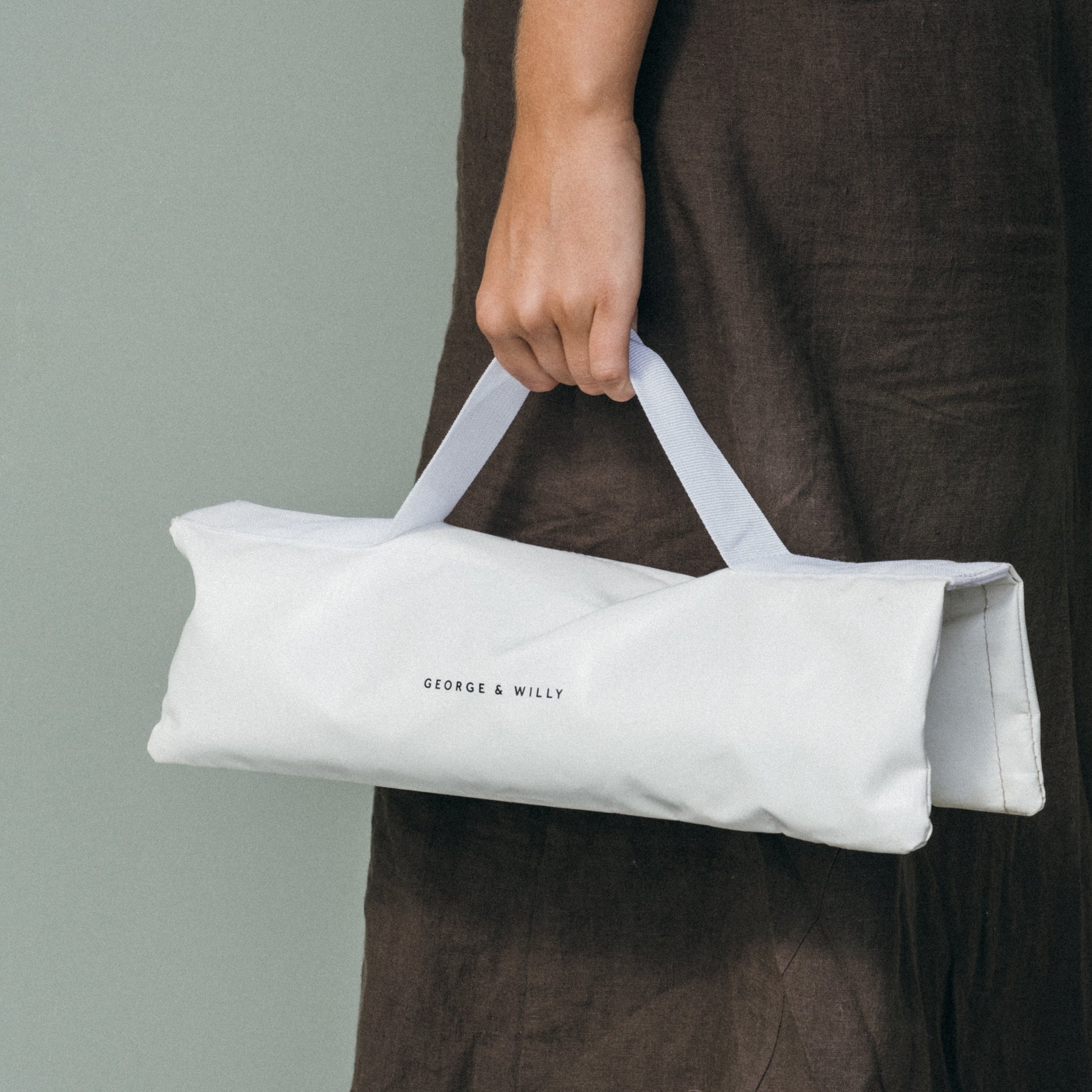 An empty white sandbag designed to weigh down an outdoor sign in windy conditions